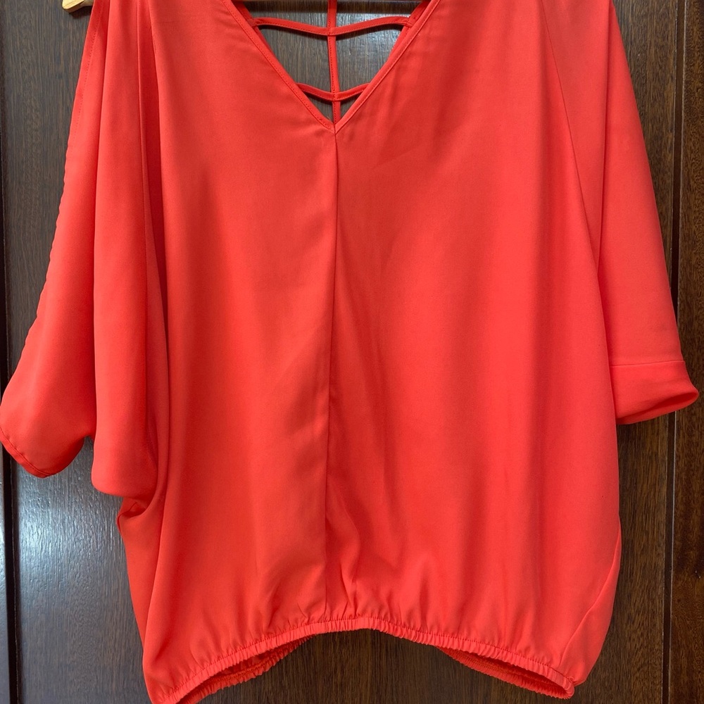 XOXO red/orange blouson top with criss-cross detail on back.